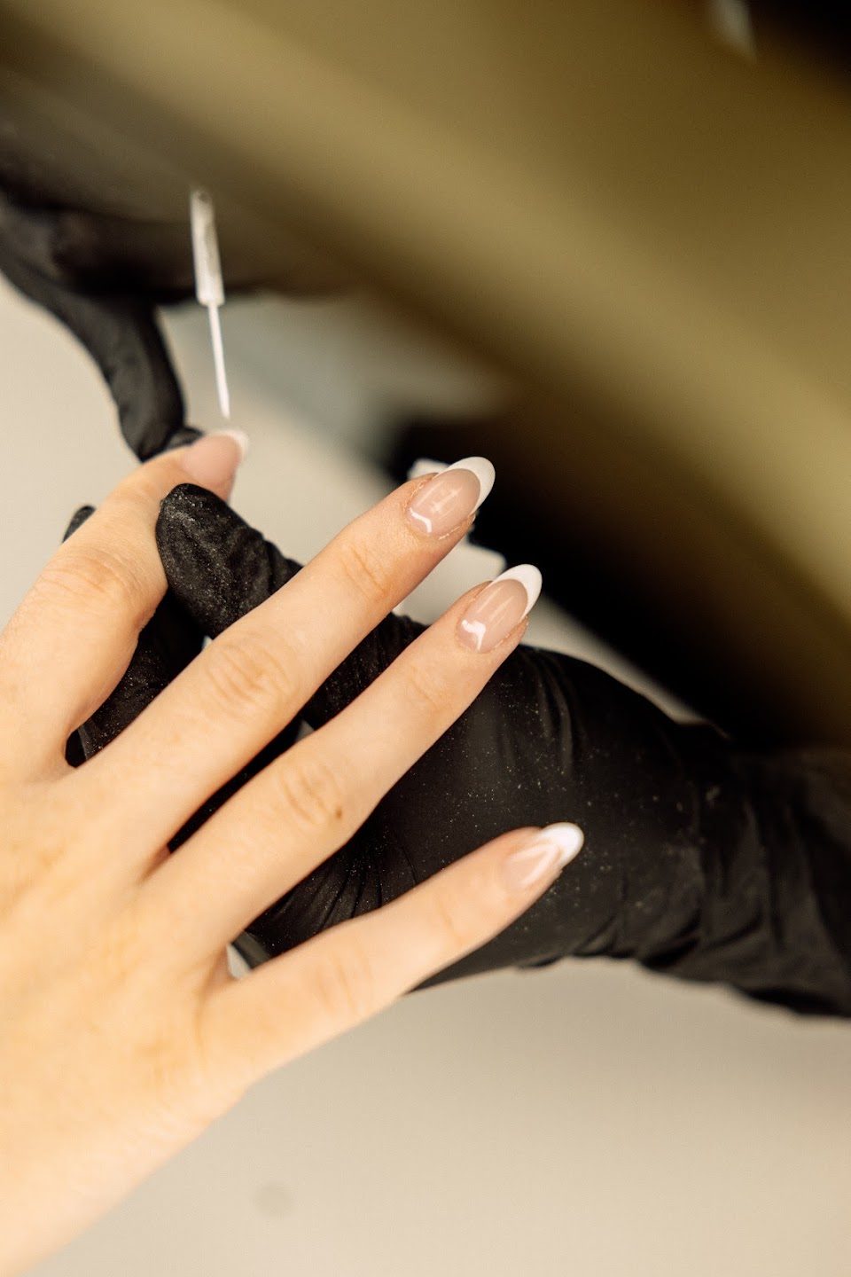 A hand with a soft white French set