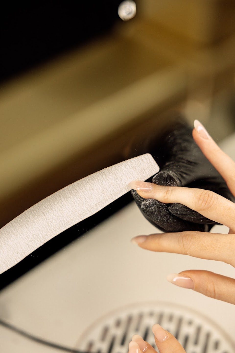 A nail technician filing a client's nails